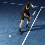 a man holding a tennis racquet on a tennis court