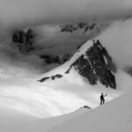 grayscale photography of man climbing on mountain