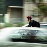 man riding bicycle near car