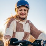 a woman wearing a helmet is riding a bike