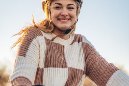 a woman wearing a helmet is riding a bike