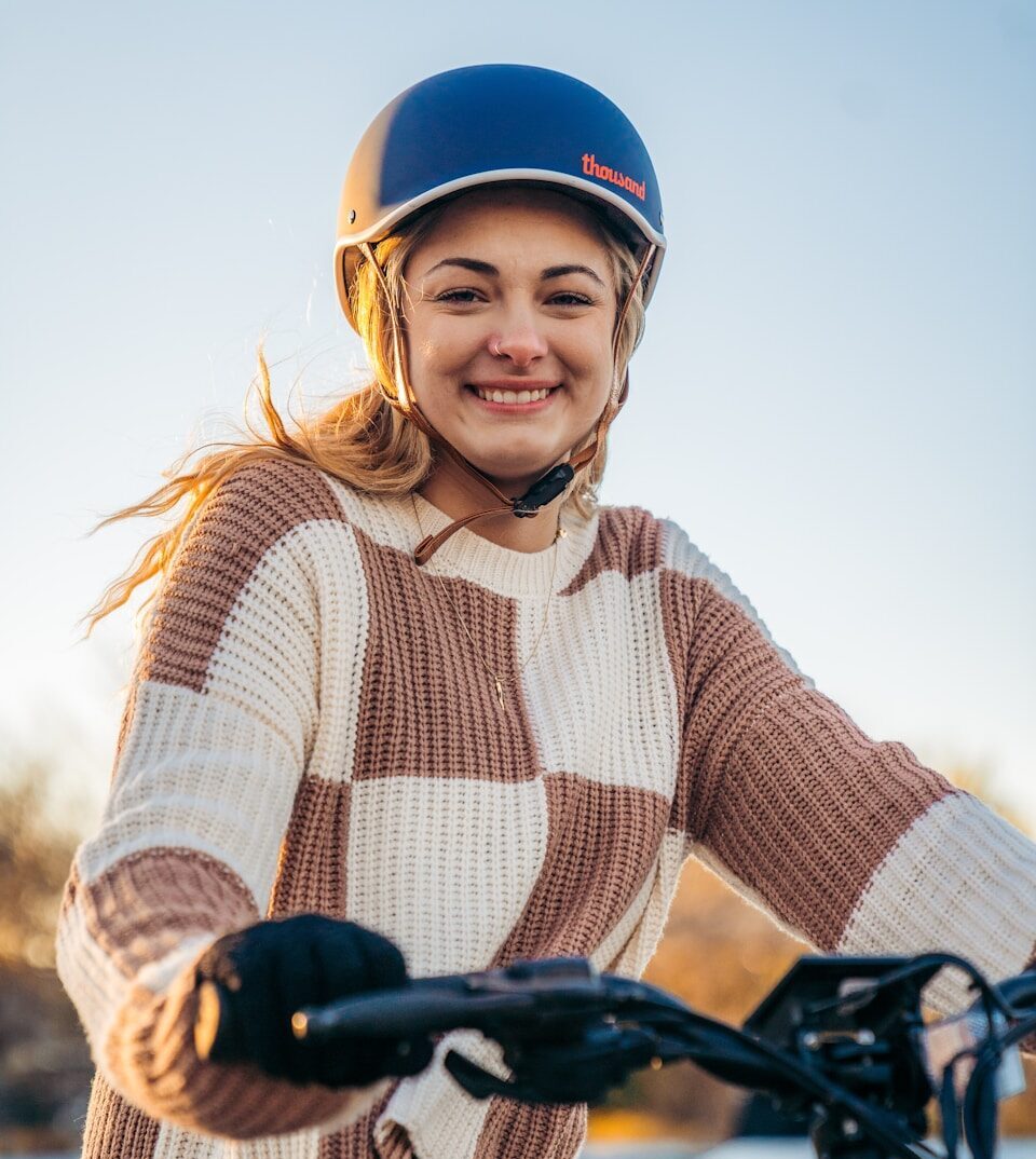 a woman wearing a helmet is riding a bike