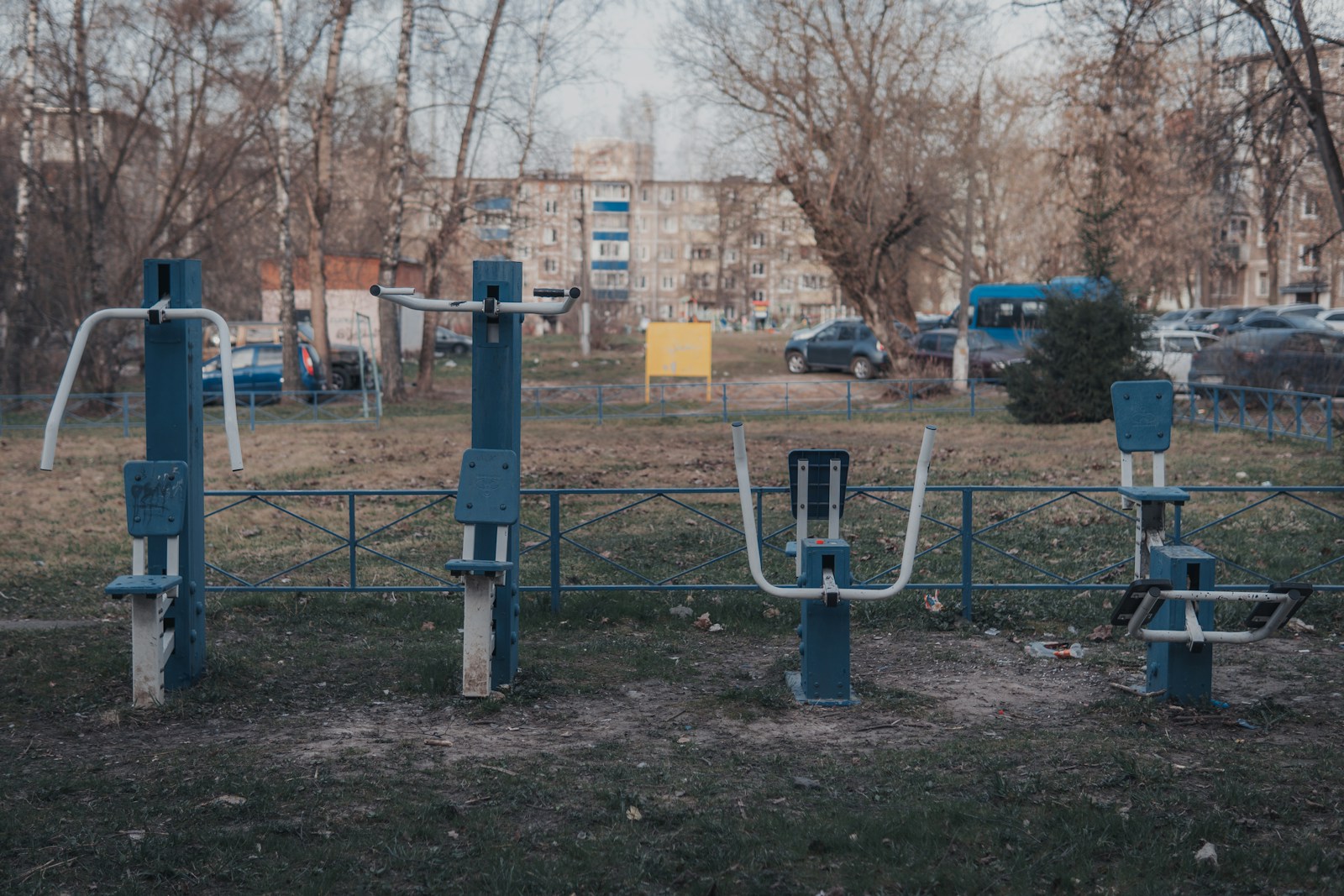 a park with a metal fence and a bunch of park benches